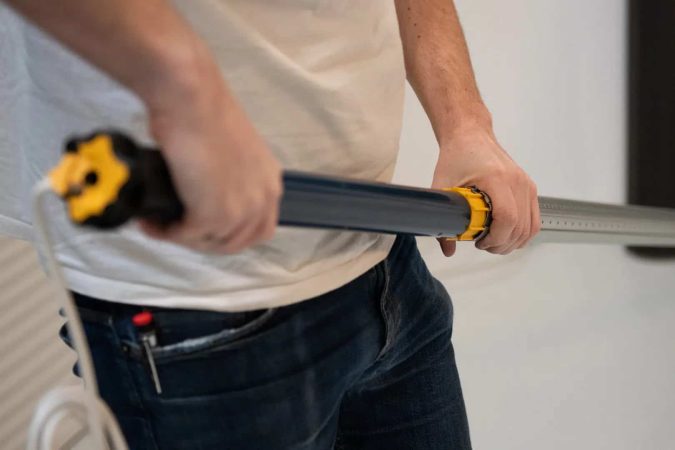 Un installateur travaille sur un mécanisme d'ouverture, facilitant l'installation avec Removo.