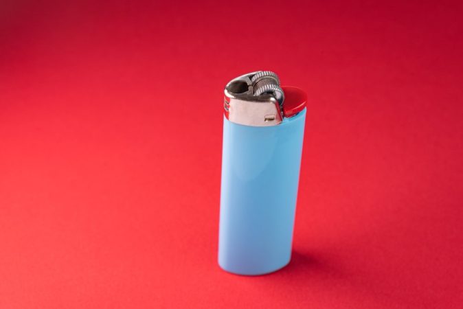 Gros plan sur un "Briquet Espion" noir au design classique, intégrant discrètement un objectif de caméra pour la surveillance cachée