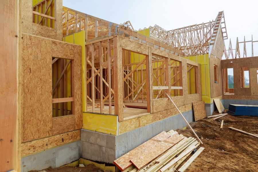 Chantier de construction avec charpente en bois à renforcer Construction d'une maison en ossature bois avec charpente apparente sur chantier