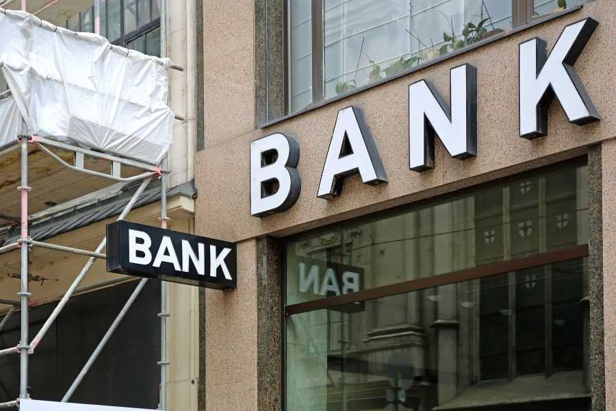 Agence bancaire et services financiers Enseigne extérieure d'une agence bancaire en lettres blanches sur façade urbaine