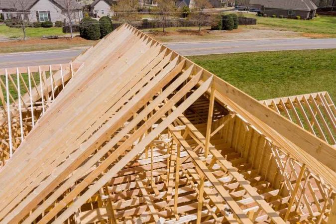 Charpente traditionnelle en bois neuf en construction vue du dessus dans un quartier résidentiel