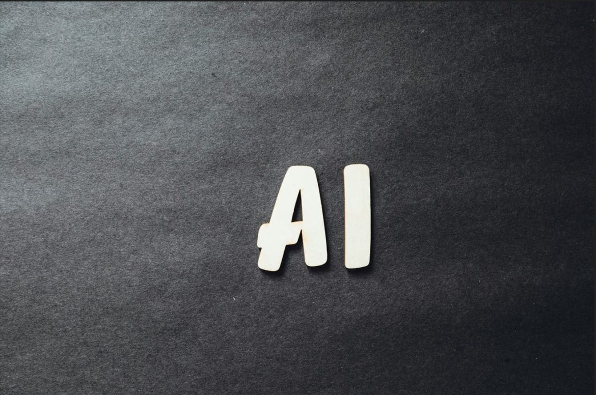 Lettres en bois formant le sigle "AI" sur un fond noir texturé, illustrant un guide intelligence artificielle 2026.