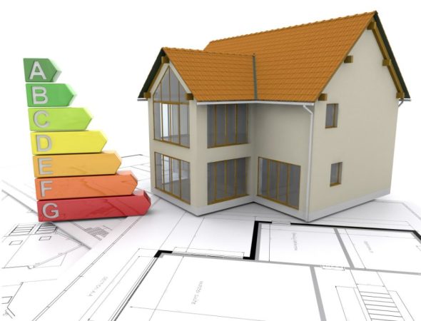 Maquette de maison posée sur des plans d'architecte à côté d'une échelle de performance énergétique DPE, évitant la baisse prix immobilier france métropole pour les logements isolés.