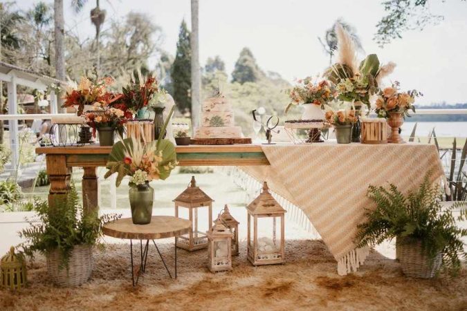 Décoration de table élégante pour un mariage bohème en extérieur avec des fleurs séchées et des lanternes.